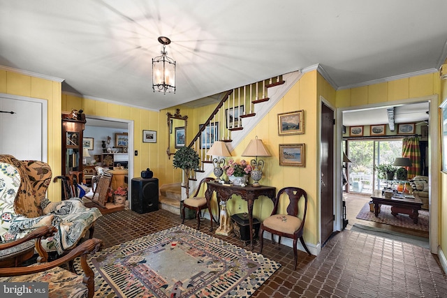 sitting room with a notable chandelier and ornamental molding