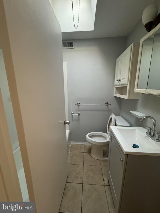 bathroom featuring tile patterned flooring, vanity, a bathtub, and toilet