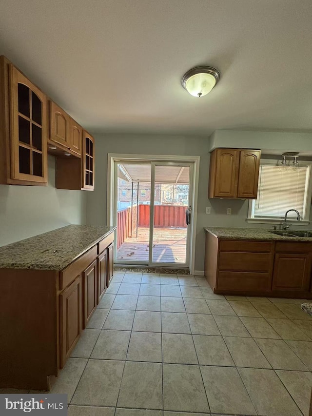 kitchen with stone countertops, sink, and light tile patterned floors