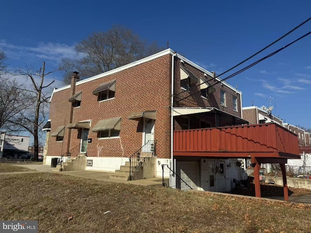 rear view of property with a yard and central air condition unit