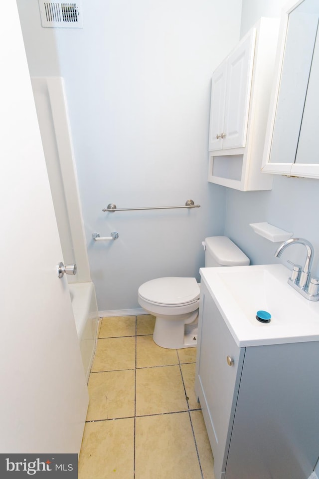 bathroom featuring tile patterned flooring, vanity, a washtub, and toilet