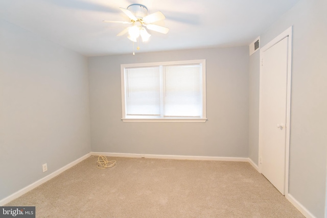 carpeted spare room featuring ceiling fan