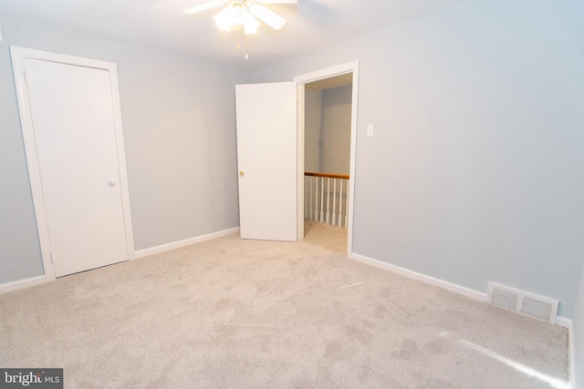 carpeted spare room with ceiling fan