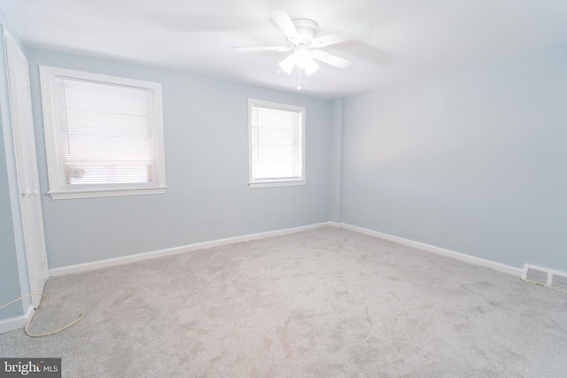 empty room featuring light colored carpet and ceiling fan