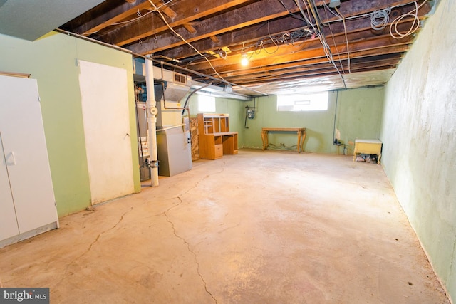 basement featuring white fridge and heating unit