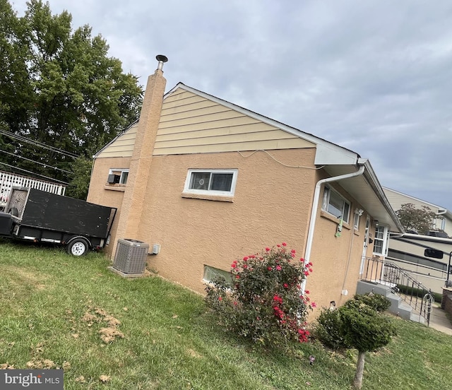 view of home's exterior featuring a yard and central AC unit