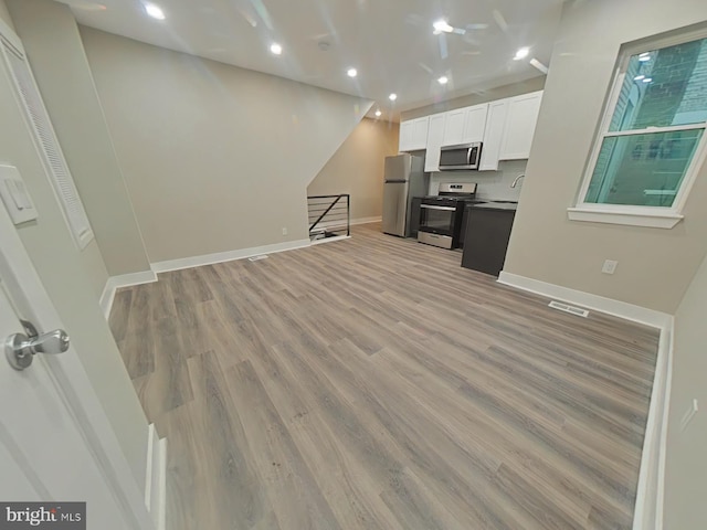 kitchen featuring white cabinetry, sink, light hardwood / wood-style flooring, and stainless steel appliances