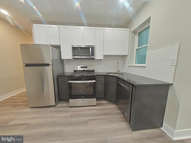 kitchen featuring white cabinetry, sink, stainless steel appliances, and light wood-type flooring