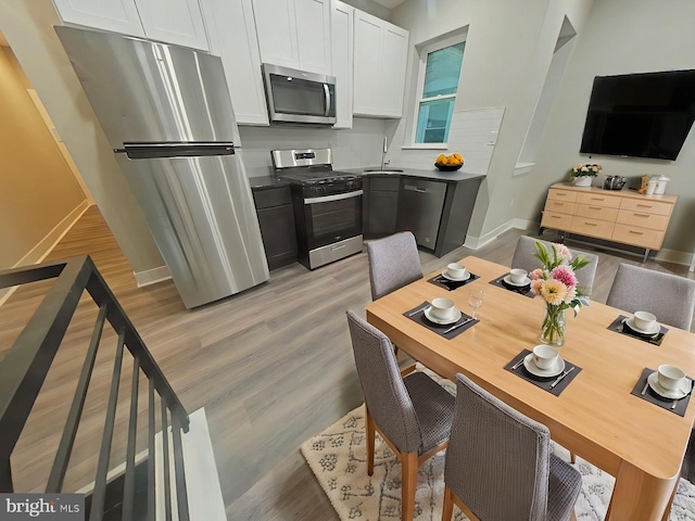 kitchen with white cabinets, stainless steel appliances, light hardwood / wood-style flooring, and sink