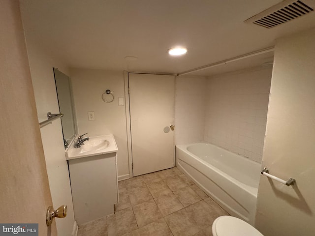 full bathroom with tile patterned floors, vanity, toilet, and tiled shower / bath combo