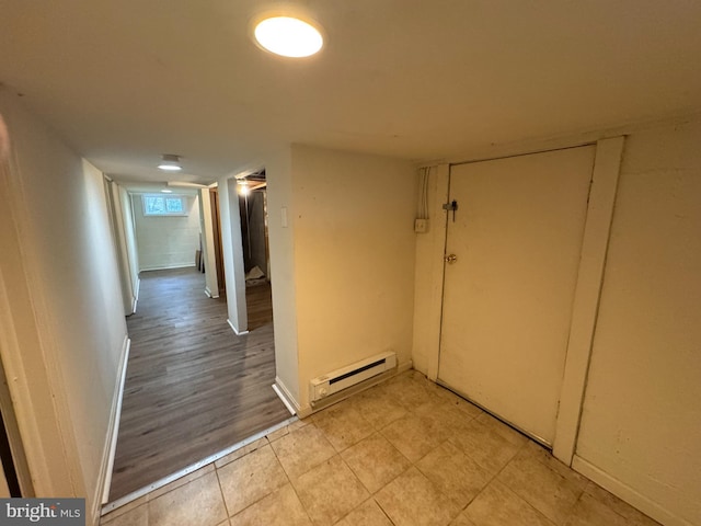 hall featuring light wood-type flooring and a baseboard heating unit