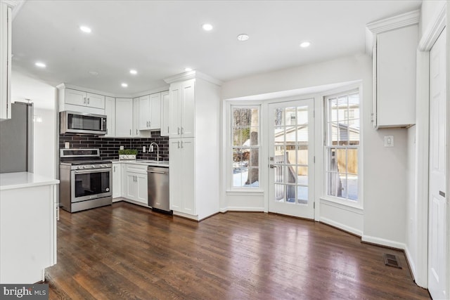 kitchen with appliances with stainless steel finishes, tasteful backsplash, white cabinetry, and sink