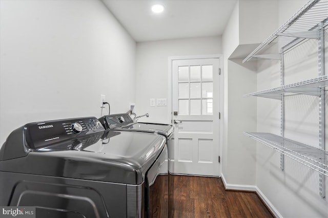 laundry room with washer and dryer and dark wood-type flooring