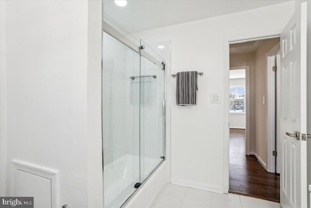 bathroom with tile patterned flooring and combined bath / shower with glass door