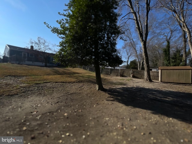 view of yard with a storage shed, fence, and an outbuilding