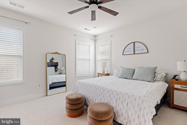 bedroom featuring light carpet, multiple windows, and ceiling fan