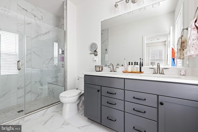 bathroom featuring vanity, a shower with shower door, and toilet