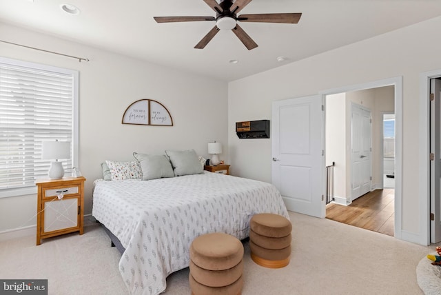 bedroom with multiple windows, ceiling fan, and light hardwood / wood-style floors