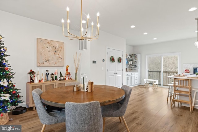 dining room with light wood-type flooring and a notable chandelier