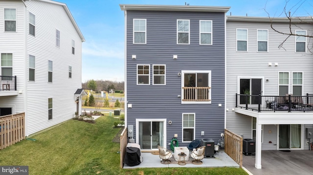 rear view of house featuring central AC unit, a patio area, and a lawn