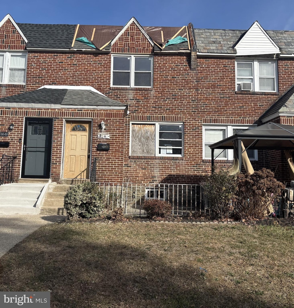 townhome / multi-family property featuring a front lawn and cooling unit