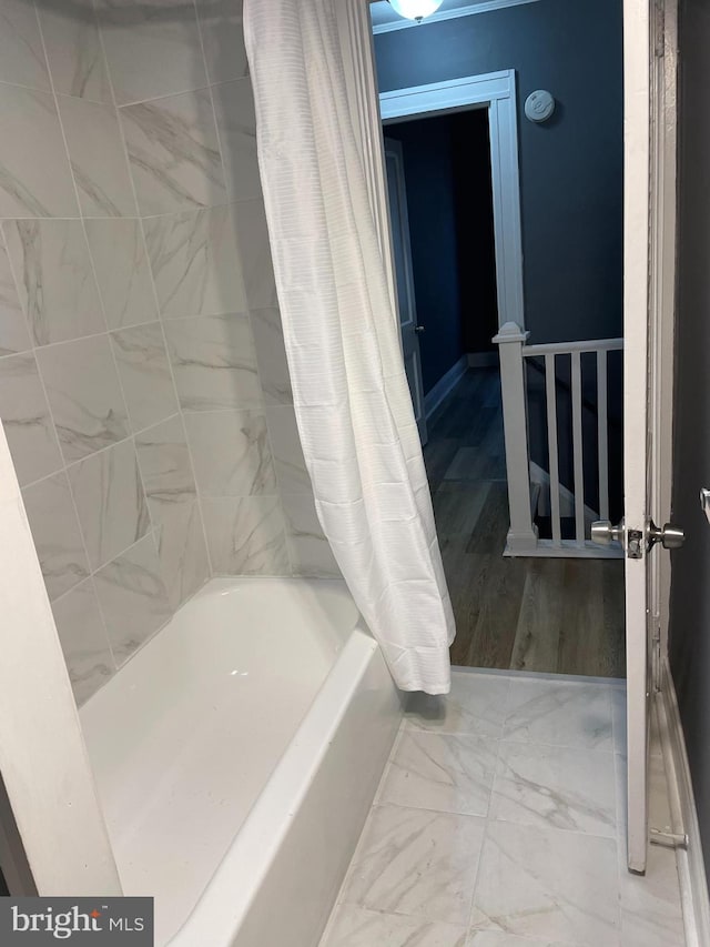 bathroom featuring hardwood / wood-style flooring and shower / bath combo with shower curtain