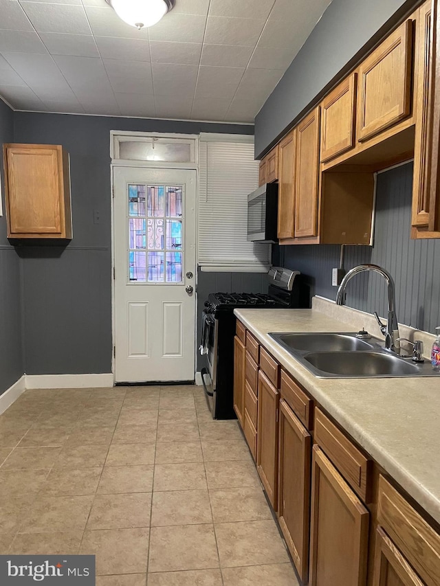 kitchen with light tile patterned flooring, sink, and stainless steel appliances