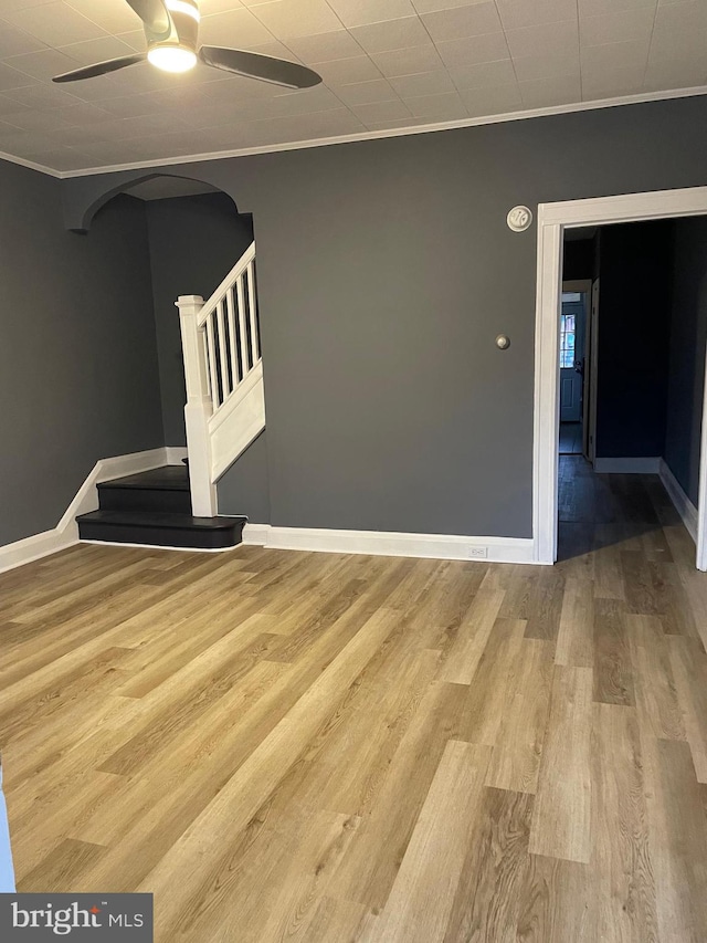 empty room featuring ceiling fan, light hardwood / wood-style floors, and ornamental molding