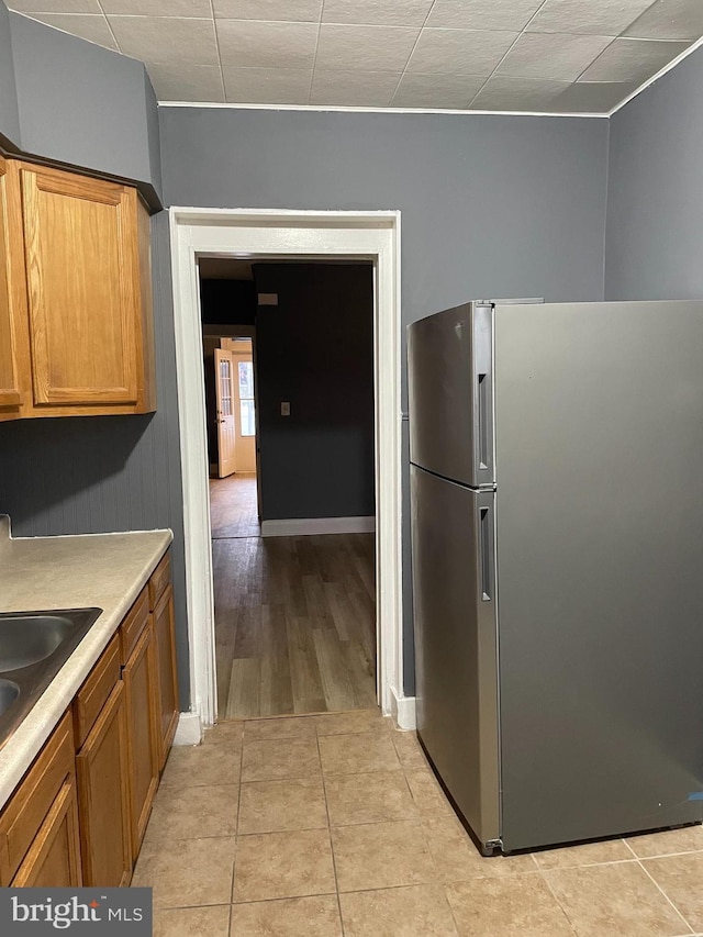 kitchen featuring sink, stainless steel refrigerator, and light hardwood / wood-style flooring