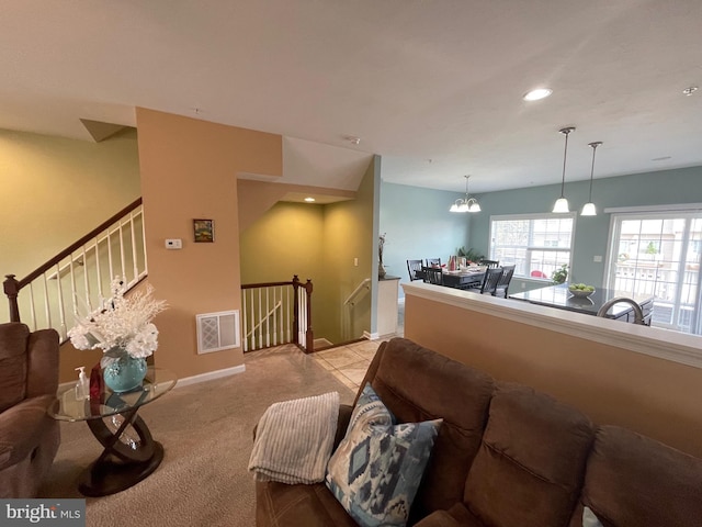 living room with light carpet and an inviting chandelier