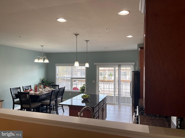 dining room with light tile patterned flooring, sink, and an inviting chandelier