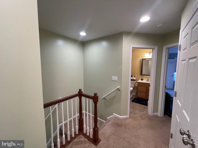 hall with light colored carpet and sink