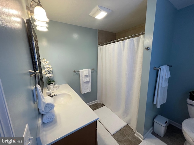 bathroom featuring curtained shower, tile patterned flooring, vanity, and toilet