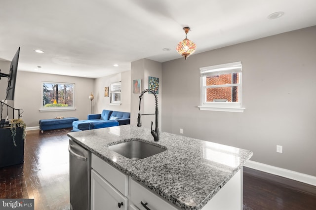 kitchen with sink, stainless steel dishwasher, dark hardwood / wood-style floors, a kitchen island with sink, and white cabinets