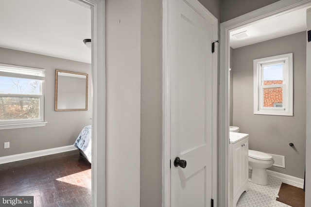 bathroom with vanity, toilet, wood-type flooring, and a wealth of natural light