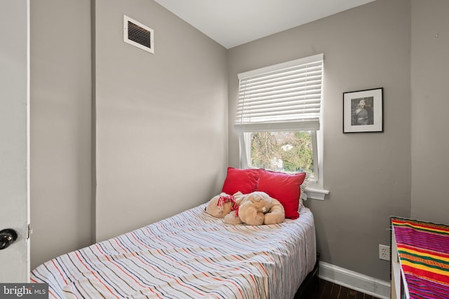 bedroom with dark hardwood / wood-style floors