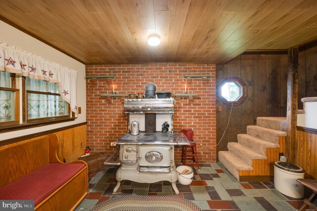 82 Quarry Rd, Birdsboro, PA 19508 - living area with wooden walls, tile patterned floors, wooden ceiling, brick wall, and stairway