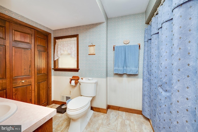 bathroom with walk in shower, tile patterned flooring, vanity, and toilet