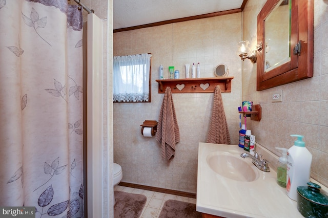 bathroom featuring tile patterned flooring, vanity, and tile walls