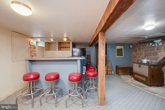 kitchen with light colored carpet, kitchen peninsula, and a breakfast bar area