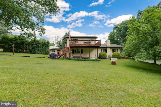 rear view of property featuring a yard and a deck