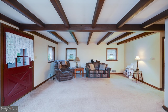 living area featuring beamed ceiling and carpet floors