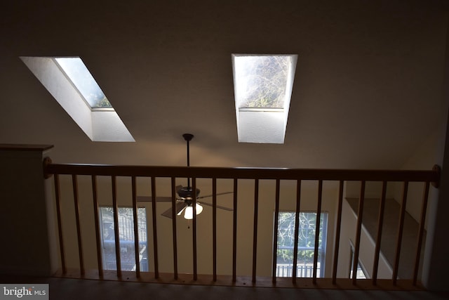 interior details featuring ceiling fan and a skylight