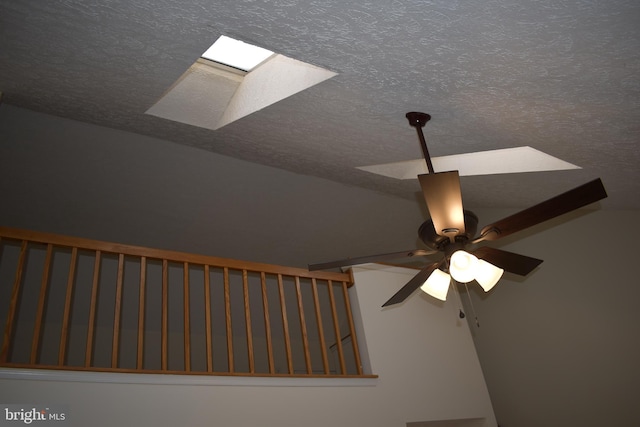 room details with a textured ceiling, a skylight, and ceiling fan