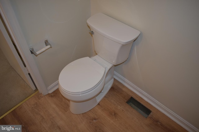 bathroom with hardwood / wood-style floors and toilet