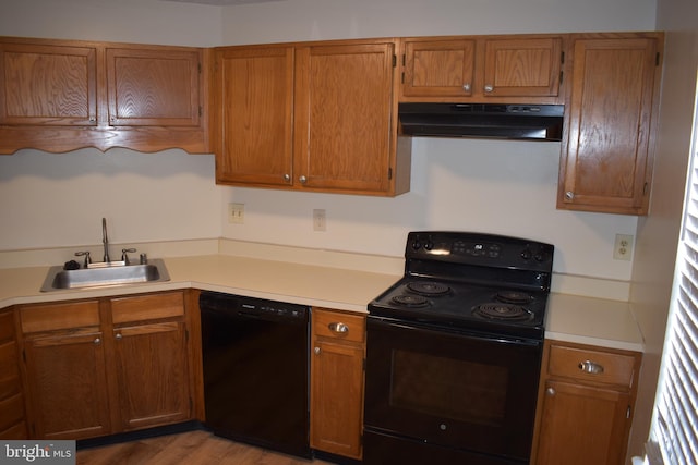 kitchen featuring black appliances, light wood-type flooring, ventilation hood, and sink