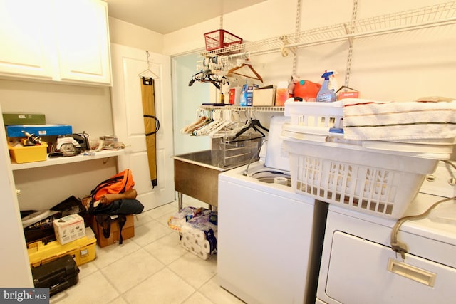 laundry area with cabinets, light tile patterned floors, and separate washer and dryer