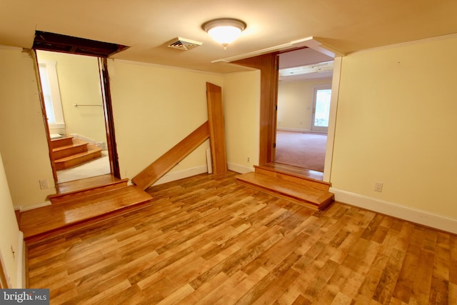 unfurnished room featuring light wood-type flooring and crown molding