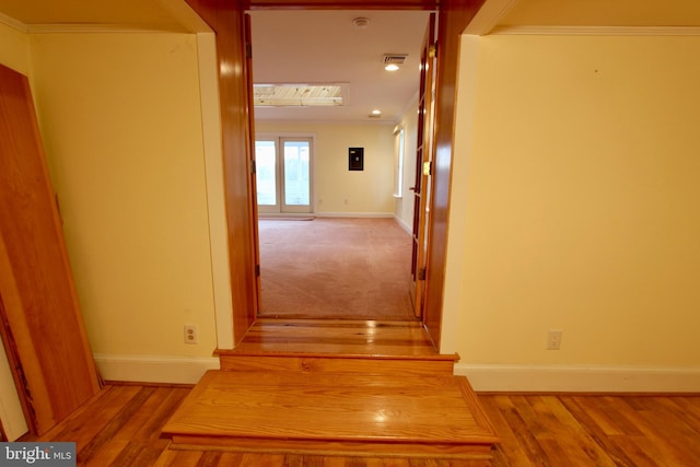 hall featuring ornamental molding and light hardwood / wood-style flooring