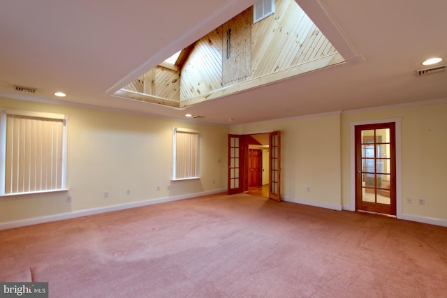 carpeted spare room with french doors, a skylight, and ornamental molding